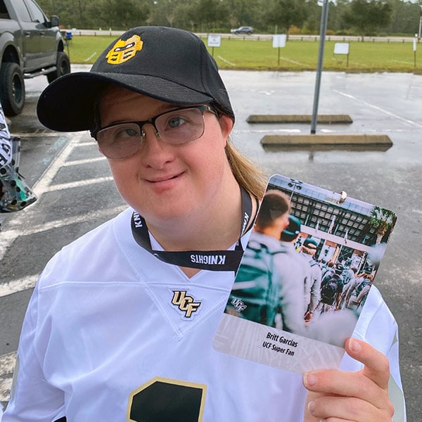 Britt posing with her UCF Super Fan card hanging on her neck by a lanyard