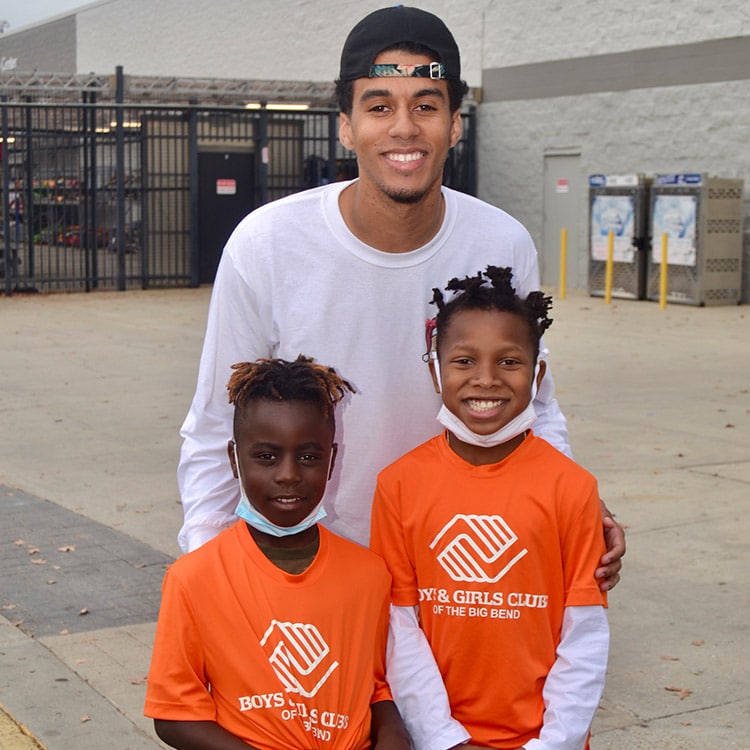 Christmas Initiative photo of children from the Boys & Girls Club posing with player Jordan Travis