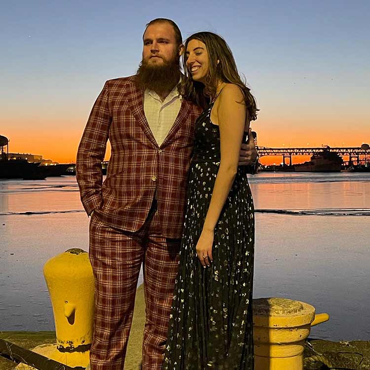 Dillan Gibbons with his fiancé posing in front of the ocean